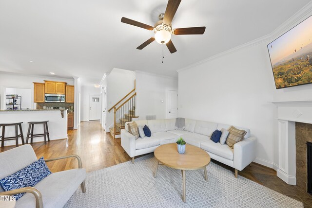 20 Paddy Ln, Youngsville, NC 27596 - living room featuring ceiling fan, stairway, crown molding, baseboards, and a tiled fireplace