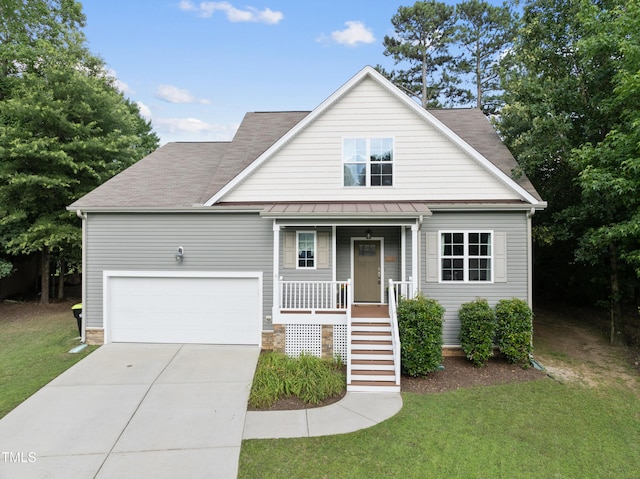 20 Paddy Ln, Youngsville, NC 27596 - view of front facade featuring covered porch, driveway, a front yard, and a standing seam roof