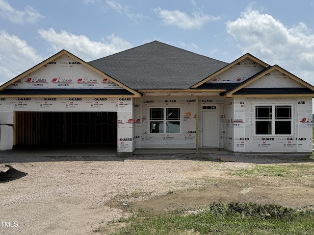 property in mid-construction featuring driveway, an attached garage, and a shingled roof