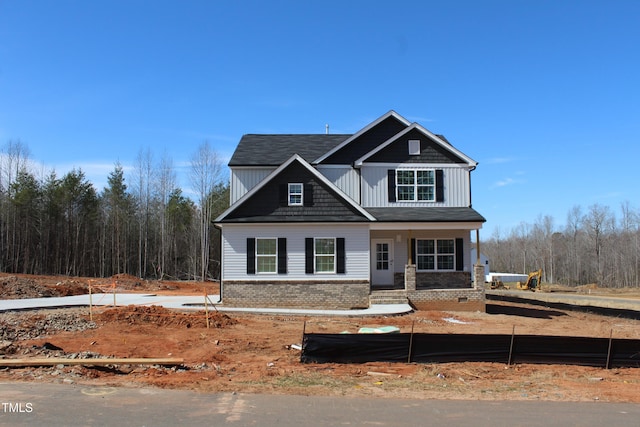 view of front of property with covered porch, board and batten siding, and brick siding