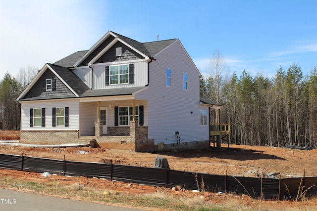 view of front of home featuring a porch, board and batten siding, and fence