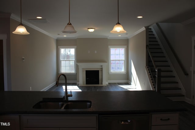kitchen with dark countertops, a sink, and dishwasher
