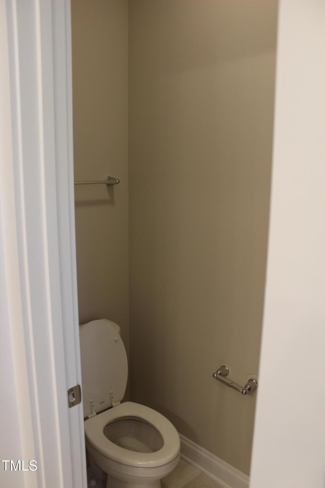 bathroom with baseboards and toilet