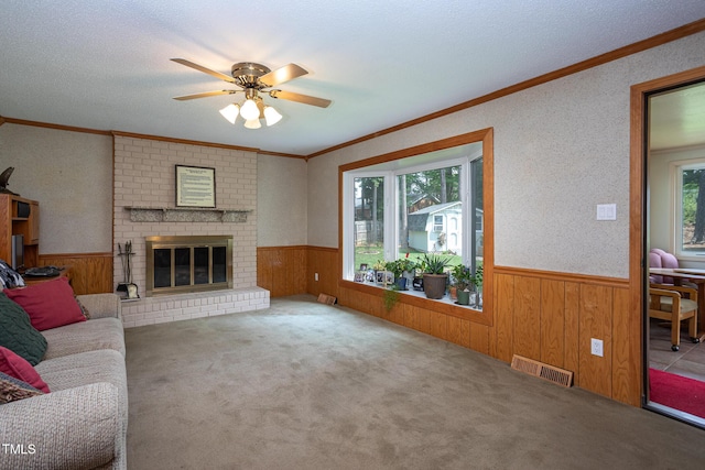 unfurnished living room with crown molding, a wainscoted wall, visible vents, and a wealth of natural light