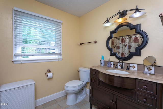 full bathroom with vanity, toilet, tile patterned floors, a textured ceiling, and baseboards