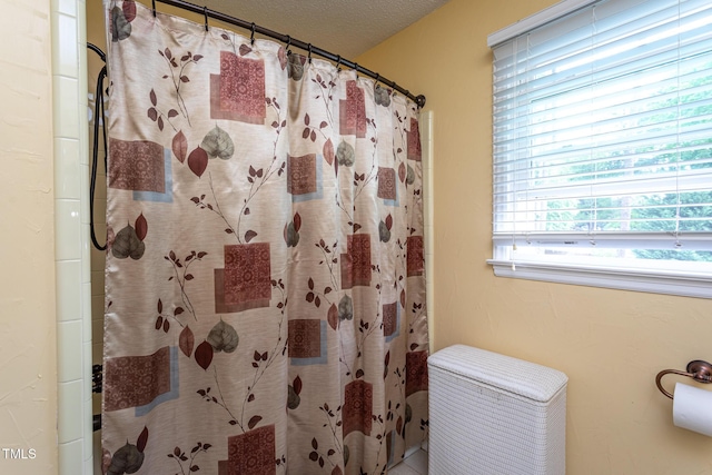 full bath with a textured ceiling and curtained shower