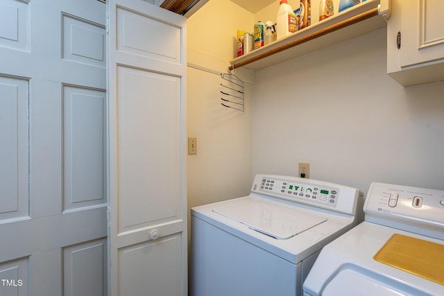 washroom featuring cabinet space and separate washer and dryer