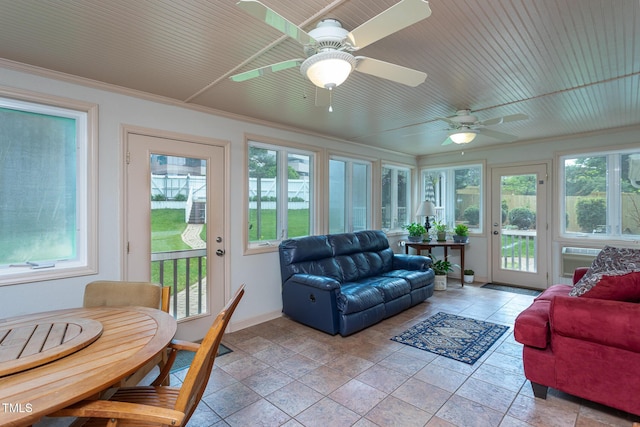 sunroom / solarium with baseboards, stone tile floors, and a wealth of natural light