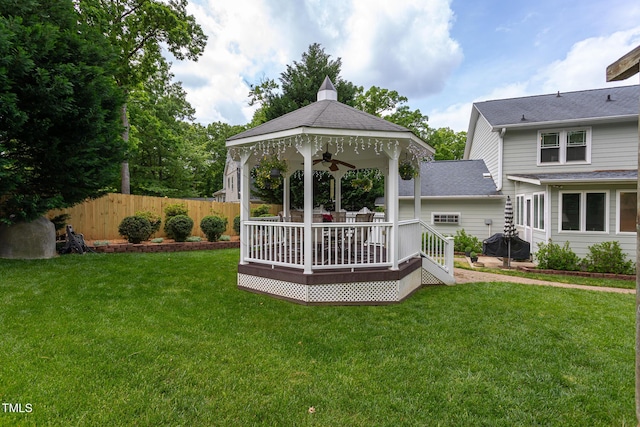 view of yard featuring a deck, a gazebo, fence, and ceiling fan