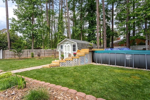 view of yard featuring a storage unit, a fenced backyard, an outbuilding, and a fenced in pool