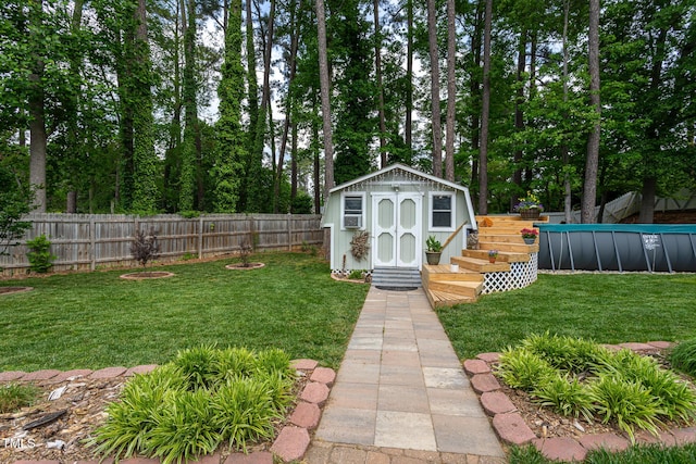 view of yard featuring a fenced in pool, an outbuilding, a fenced backyard, and a shed