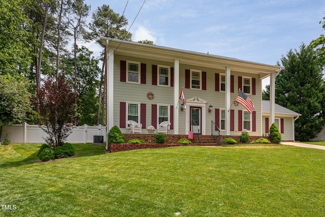 greek revival house with a porch, central AC, fence, and a front lawn