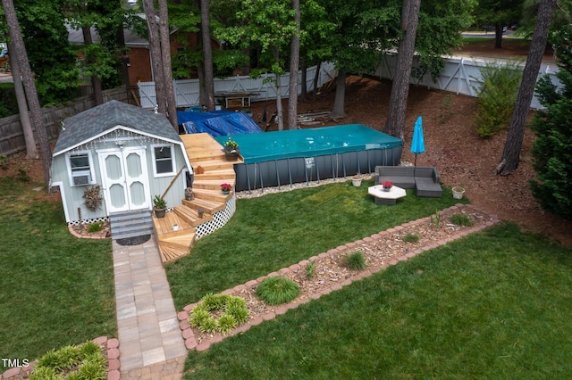 view of yard with a wooden deck, a fenced backyard, a shed, a jacuzzi, and an outbuilding