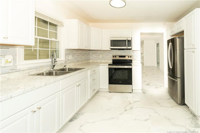 2513 Colgate Dr, Fayetteville, NC 28304 - kitchen featuring appliances with stainless steel finishes, a sink, light marble finish floors, white cabinetry, and tasteful backsplash