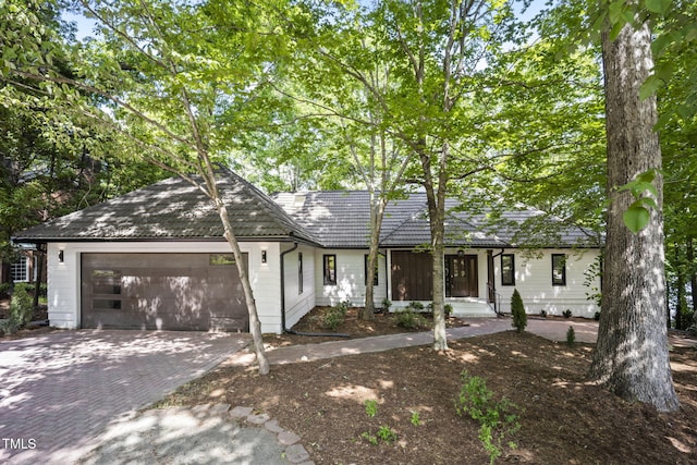 ranch-style house with decorative driveway and a garage