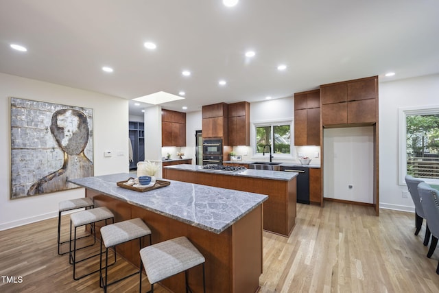 kitchen featuring a kitchen island, light wood-type flooring, modern cabinets, and dishwasher