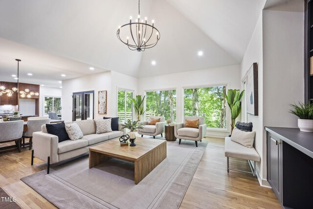living area featuring an inviting chandelier, a wealth of natural light, and high vaulted ceiling