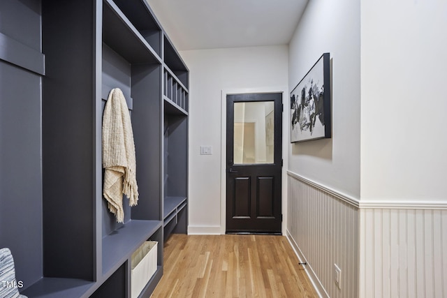 mudroom with light wood finished floors and a wainscoted wall