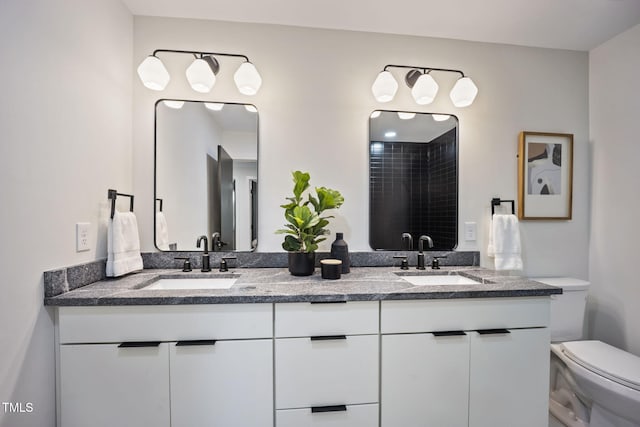 bathroom featuring double vanity, a sink, a shower, and toilet