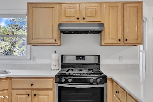 kitchen featuring stainless steel range with gas cooktop, under cabinet range hood, and light brown cabinets