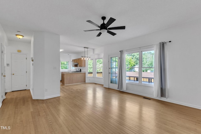 unfurnished living room with light wood-style floors, a ceiling fan, baseboards, and visible vents