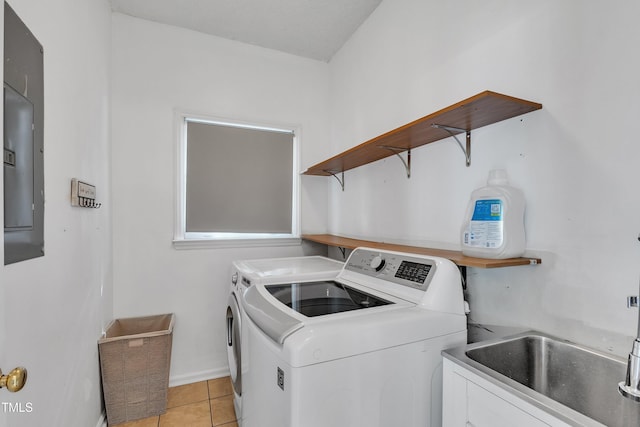 laundry room featuring laundry area, baseboards, light tile patterned floors, washing machine and dryer, and electric panel