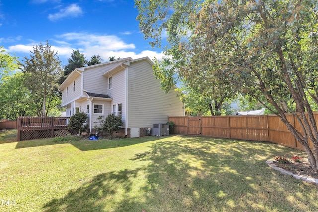 view of side of property with central air condition unit, a fenced backyard, a wooden deck, and a yard