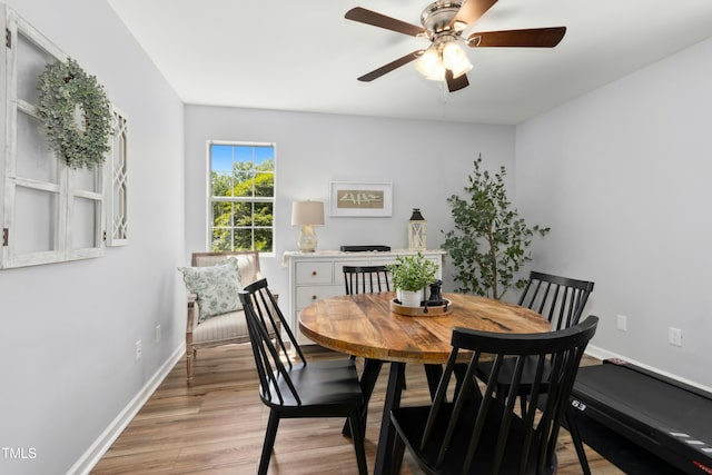 dining space featuring ceiling fan, baseboards, and light wood finished floors