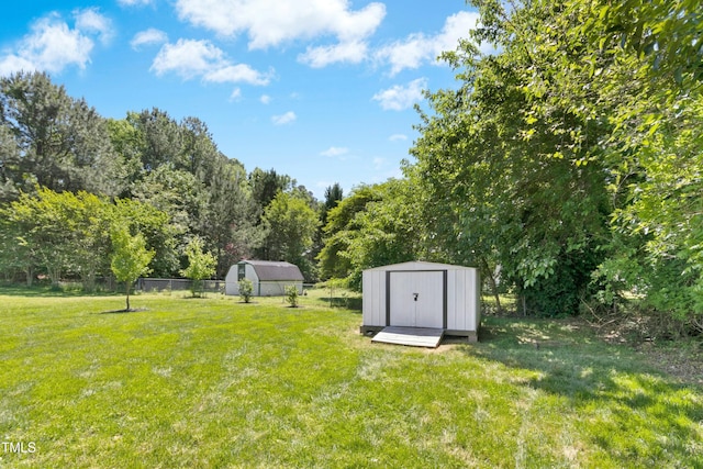 view of yard with fence, an outdoor structure, and a storage unit