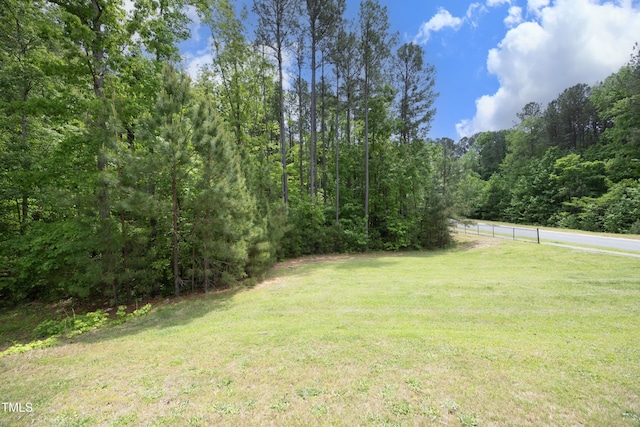 view of yard with fence and a forest view