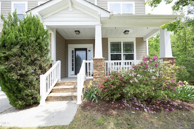 view of exterior entry featuring covered porch