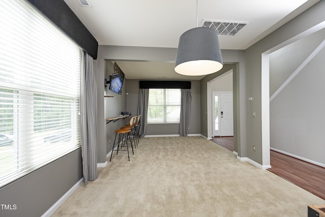 interior space with carpet flooring, baseboards, and visible vents