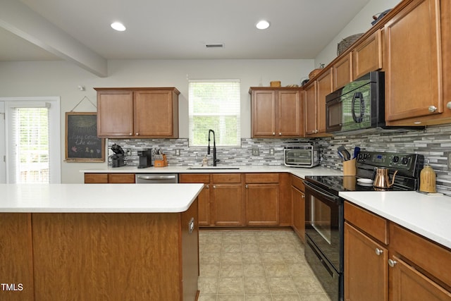 kitchen with light countertops, a healthy amount of sunlight, a sink, and black appliances