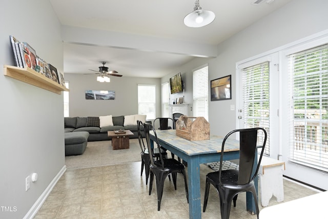 dining space with baseboards, a ceiling fan, visible vents, and a fireplace