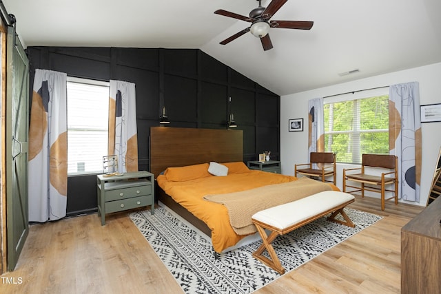 bedroom featuring ceiling fan, visible vents, light wood-style flooring, and lofted ceiling
