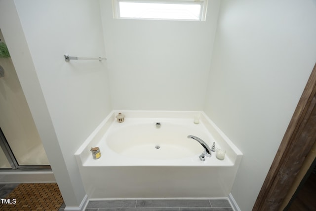 bathroom featuring tile patterned floors, a stall shower, and a bath