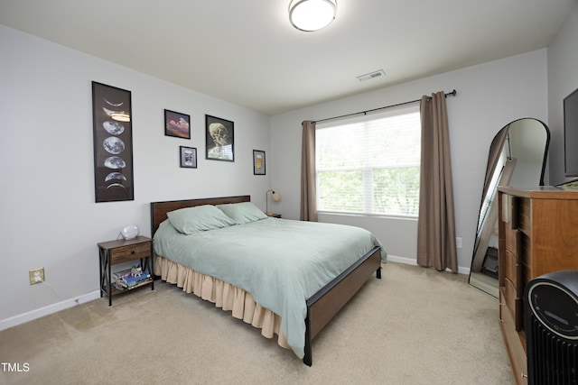 bedroom with visible vents, baseboards, and light colored carpet