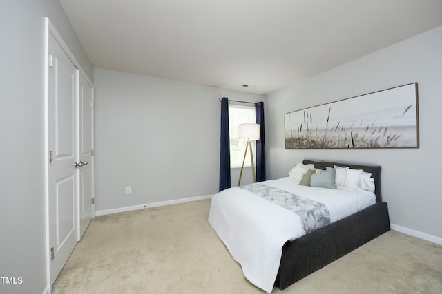 bedroom with baseboards and light carpet