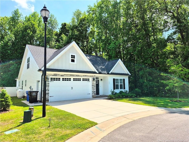view of front of property with board and batten siding, roof with shingles, a front lawn, concrete driveway, and an attached garage