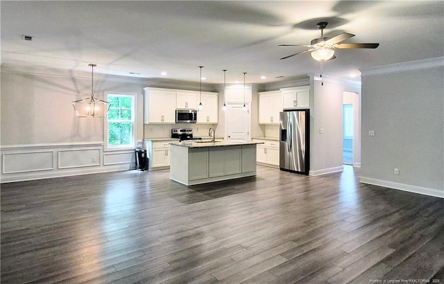kitchen with crown molding, open floor plan, an island with sink, and stainless steel appliances