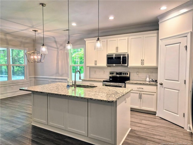 kitchen featuring a sink, appliances with stainless steel finishes, white cabinets, and ornamental molding