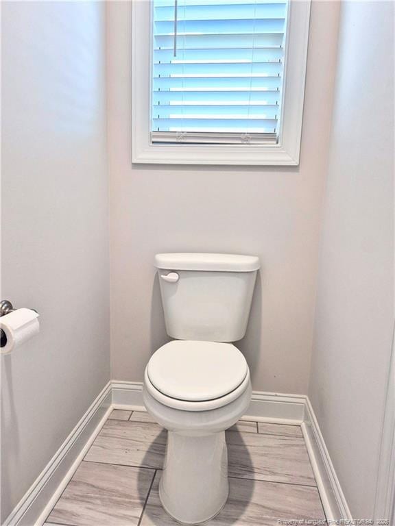 bathroom with baseboards and toilet
