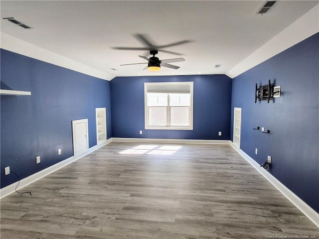 unfurnished room with a ceiling fan, vaulted ceiling, and visible vents
