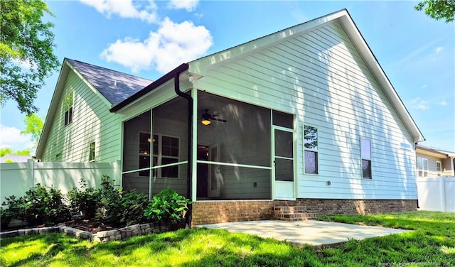 rear view of house featuring ceiling fan, fence, a sunroom, a patio area, and a yard