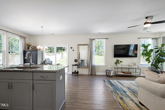 kitchen featuring gray cabinetry, a sink, a healthy amount of sunlight, and open floor plan
