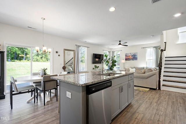 kitchen featuring visible vents, stainless steel dishwasher, a sink, open floor plan, and light wood-style floors