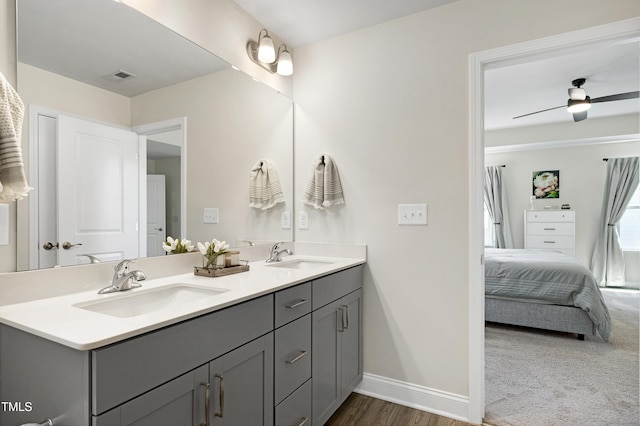 ensuite bathroom featuring baseboards, a sink, ensuite bathroom, and double vanity