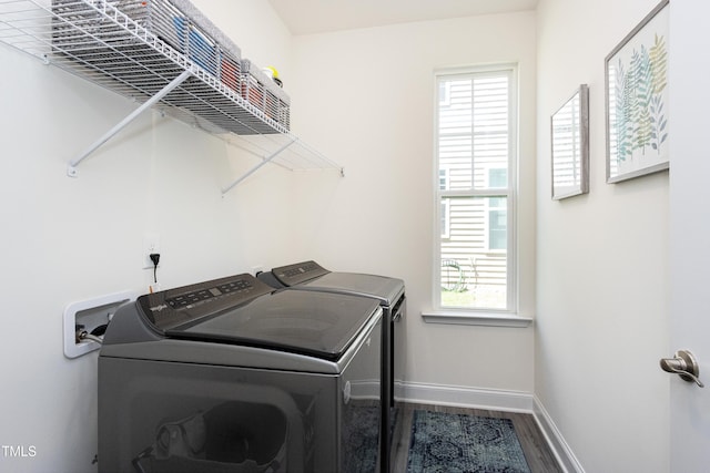 laundry room with laundry area, washer and clothes dryer, baseboards, and wood finished floors