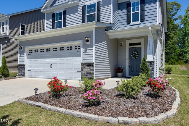 view of front facade with concrete driveway, an attached garage, and stone siding