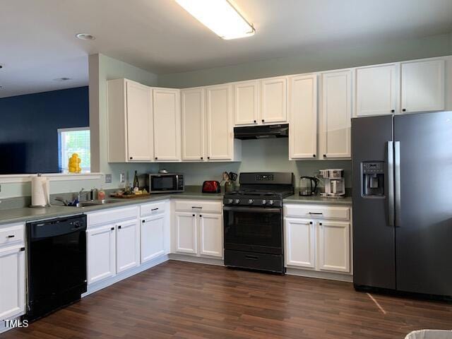 kitchen with dark wood finished floors, under cabinet range hood, black appliances, and white cabinets